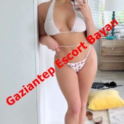 Woman in a white bikini taking a mirror selfie in a bright room; red diagonal text overlay reads 'Gaziantep Escort Bayan'.