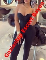 Promotional mirror selfie of a woman in a strapless black jumpsuit at a salon, with a red diagonal escort banner across the image.